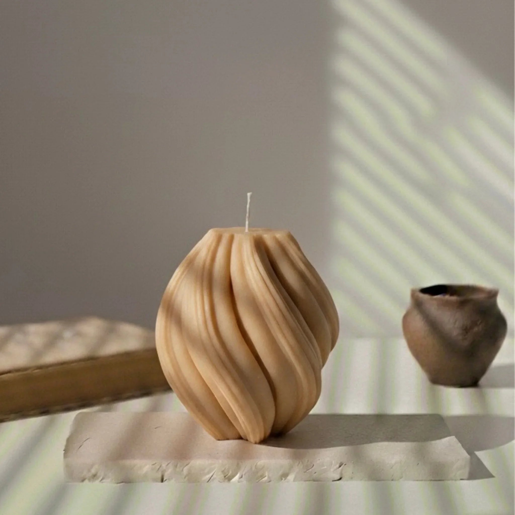 Bougie décorative spirale marron sur table blanche, style artisanal L’Atelier Rochelais