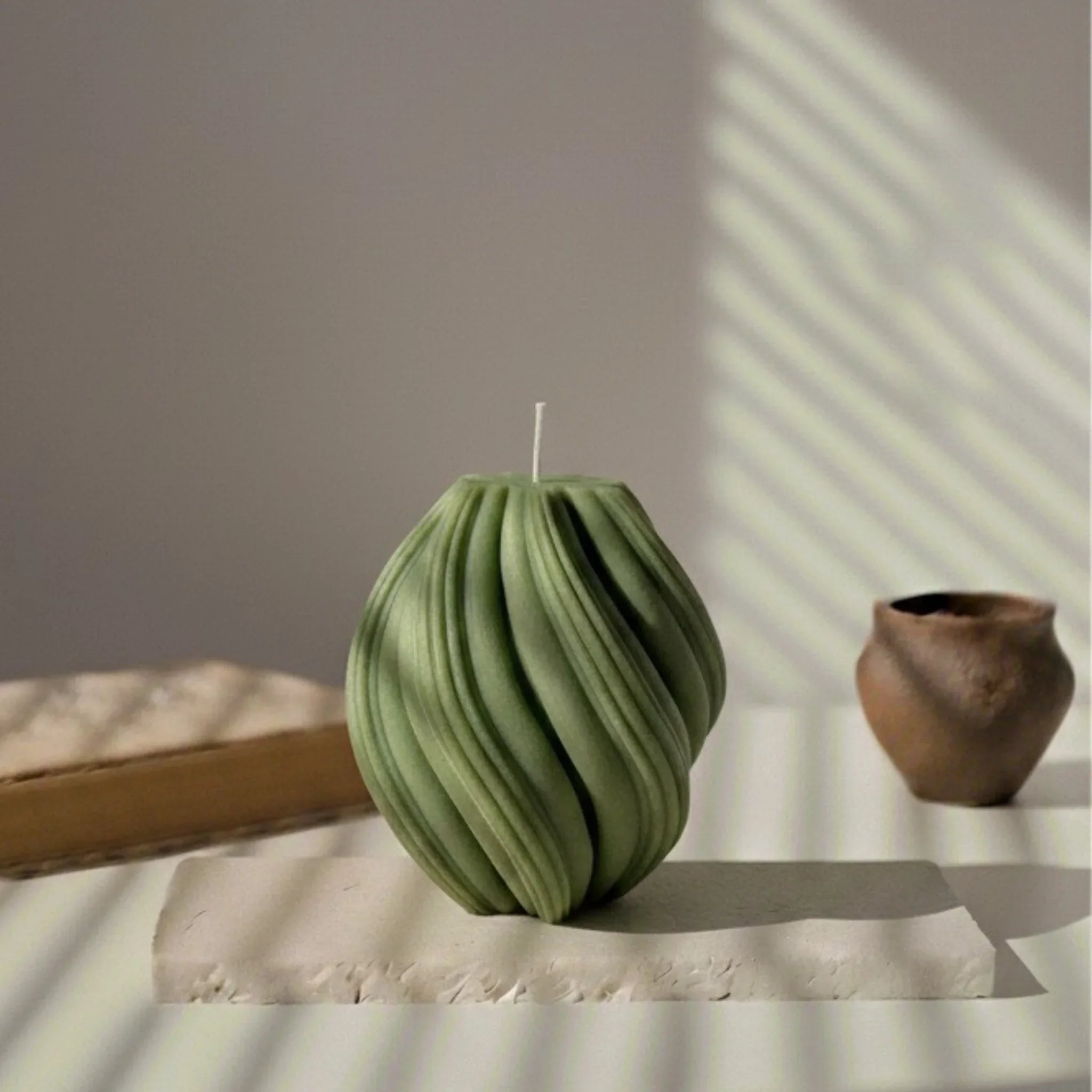 Bougie décorative spirale vert kaki sur table, style artisanal L'Atelier Rochelais