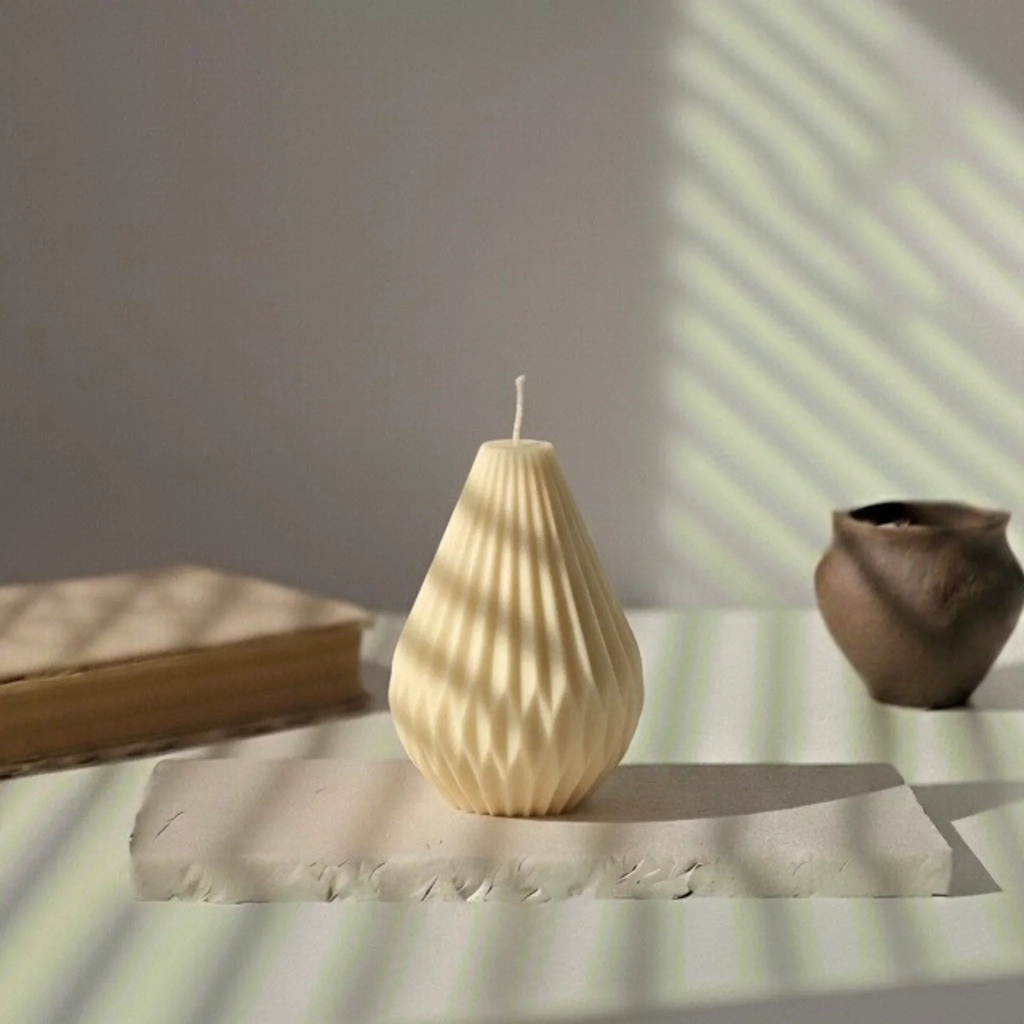 Bougie décorative blanche en forme de montgolfière sur une table, lumière naturelle, L'Atelier Rochelais