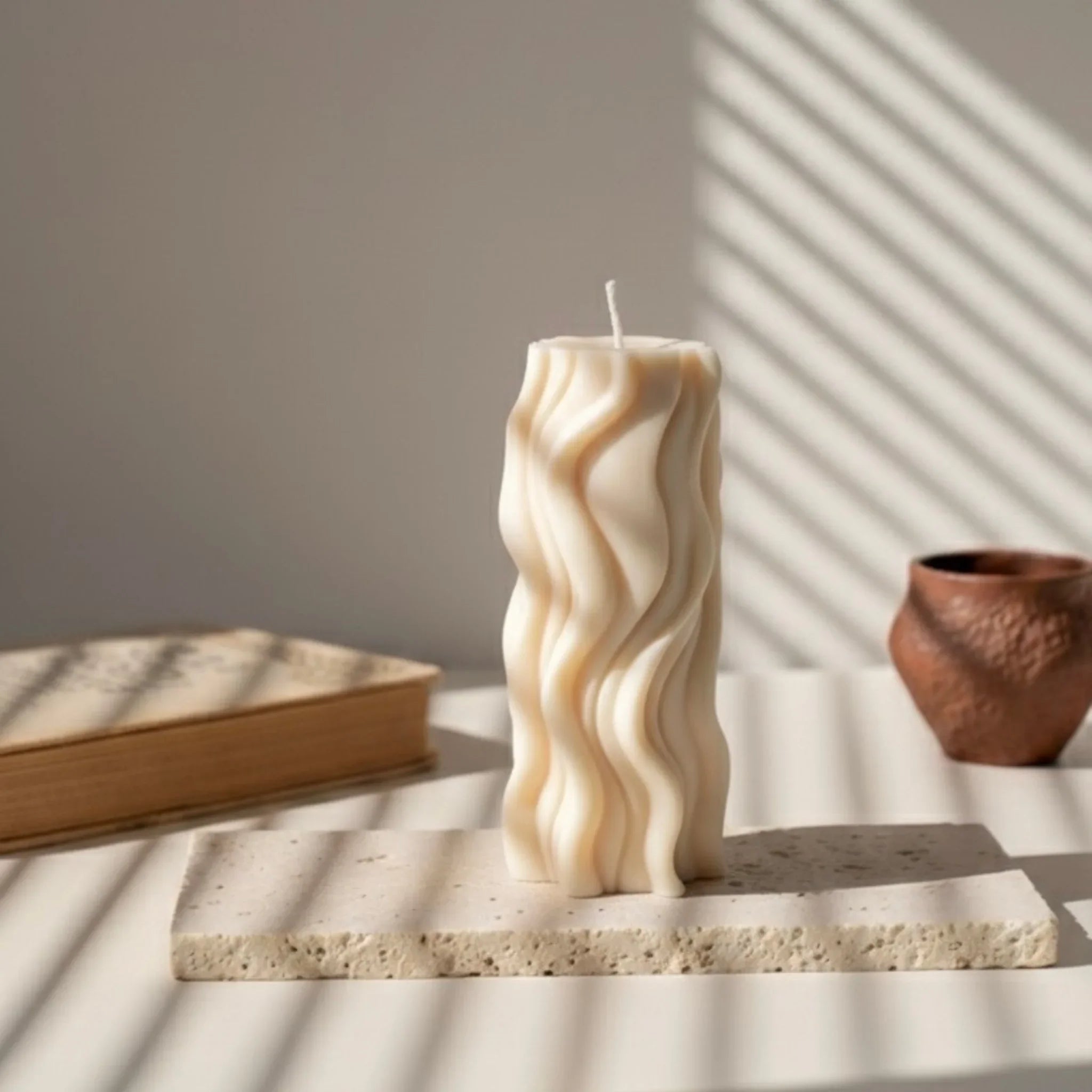 Bougie ivoire design vague sur table, lumière naturelle, décoration élégante L'Atelier Rochelais