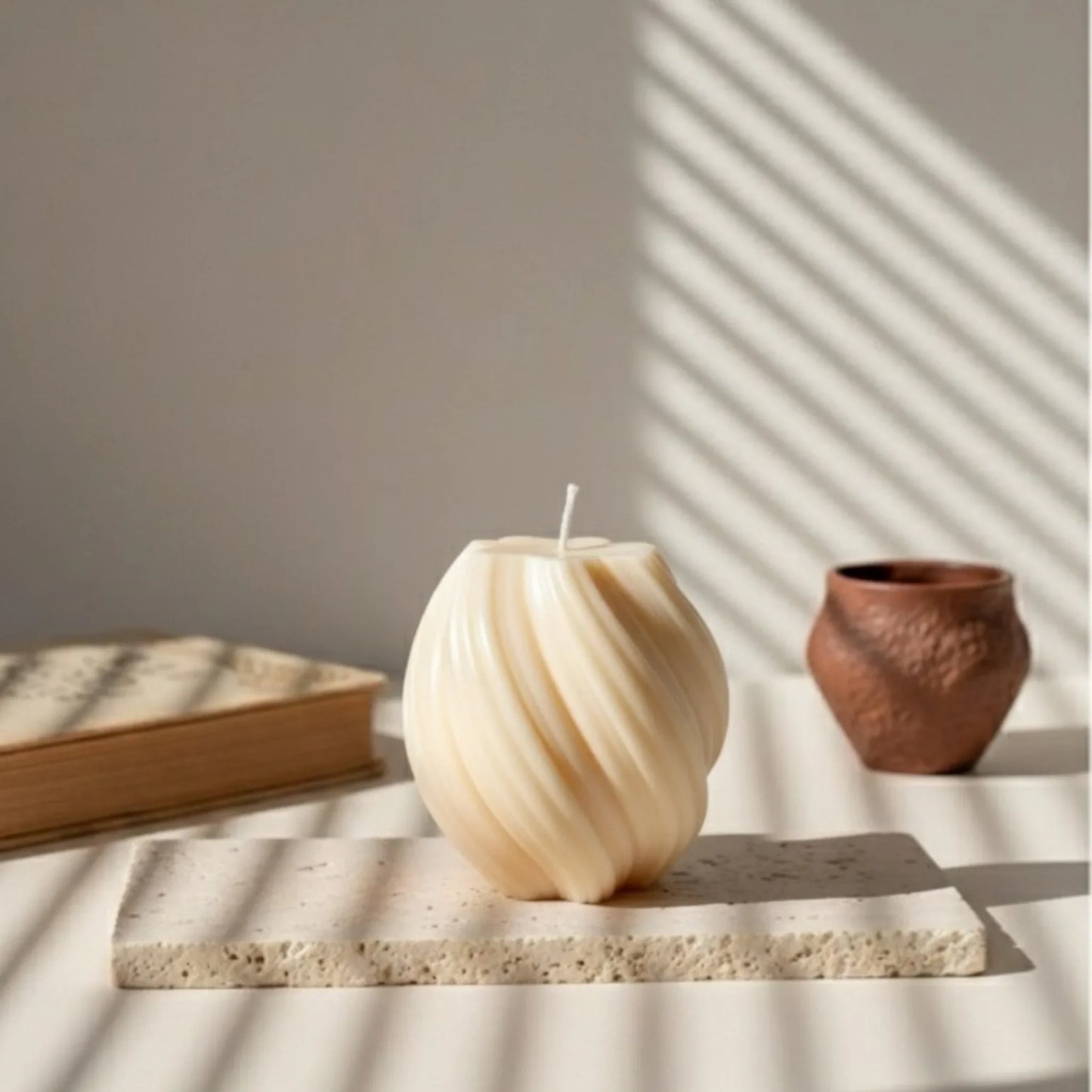 Bougie spirale ivoire design posée sur pierre, déco artisanale élégante L’Atelier Rochelais