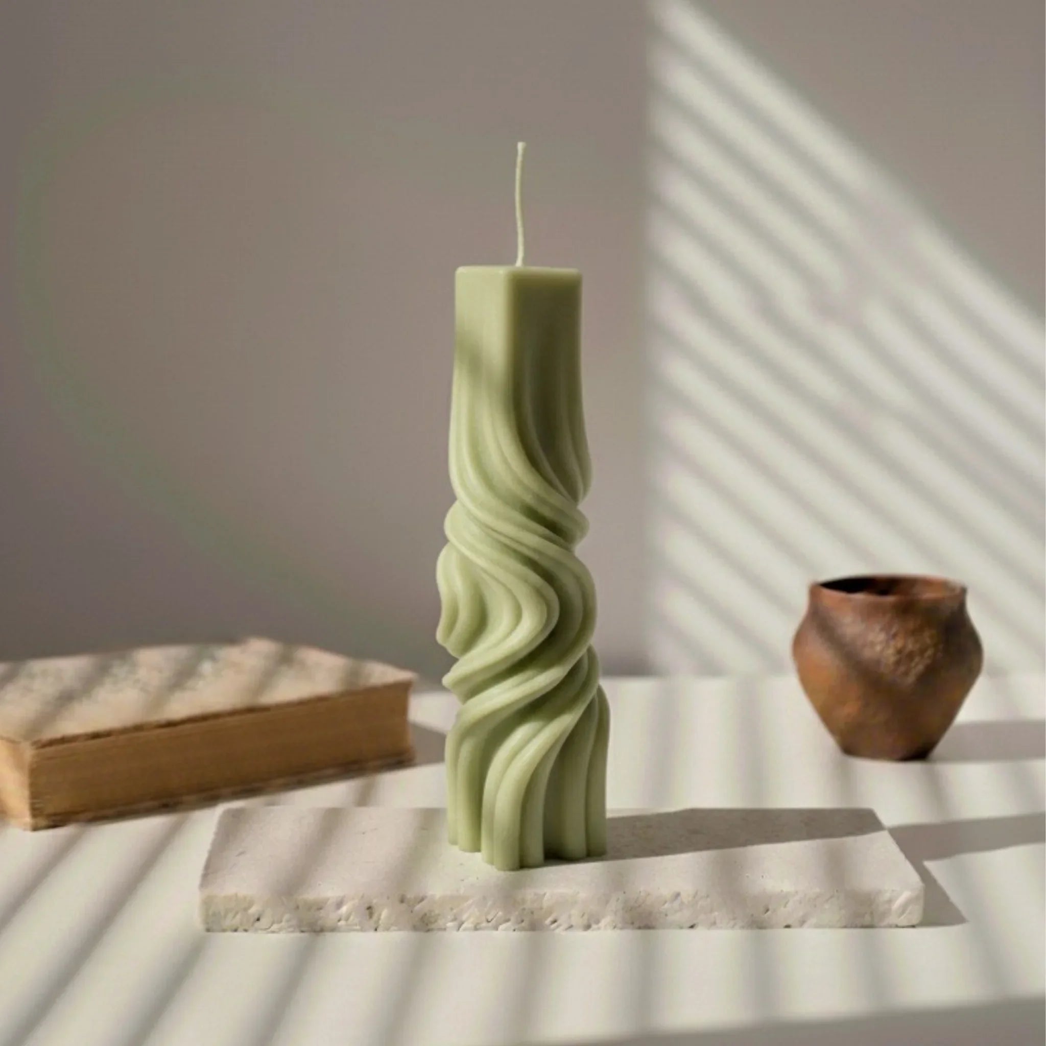 Bougie totem décorative vert kaki sur socle, lumière naturelle, design élégant, L'Atelier Rochelais