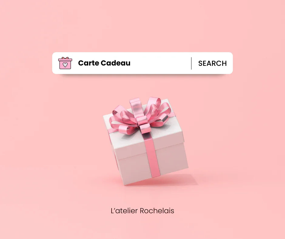 Carte cadeau L'Atelier Rochelais, boîte cadeau blanche avec ruban rose sur fond rose.