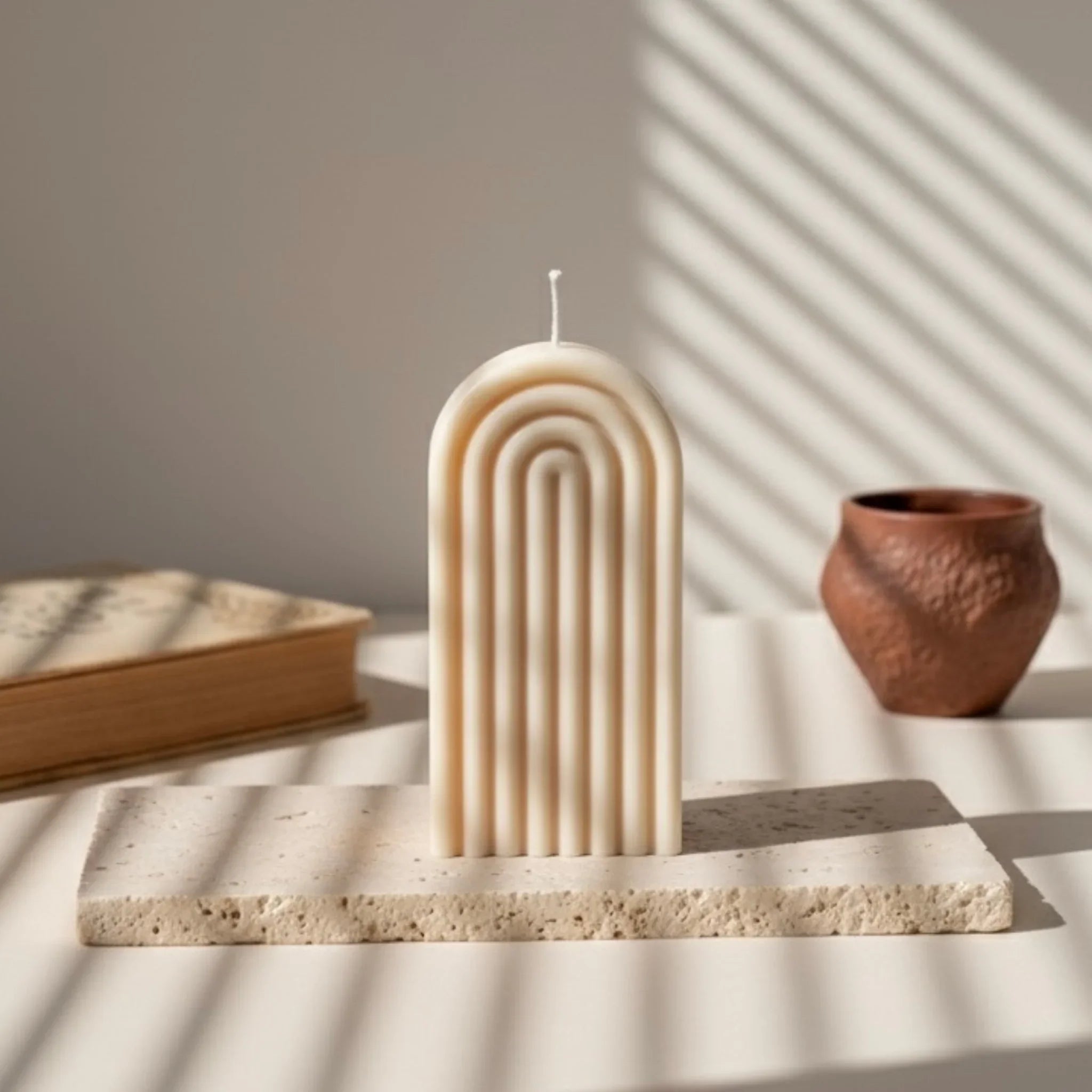 Bougie arche ivoire design minimaliste sur support pierre, décor de L'Atelier Rochelais