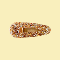 Barrette artisanale pailletée dorée L'Atelier Rochelais sur fond beige, bijou élégant