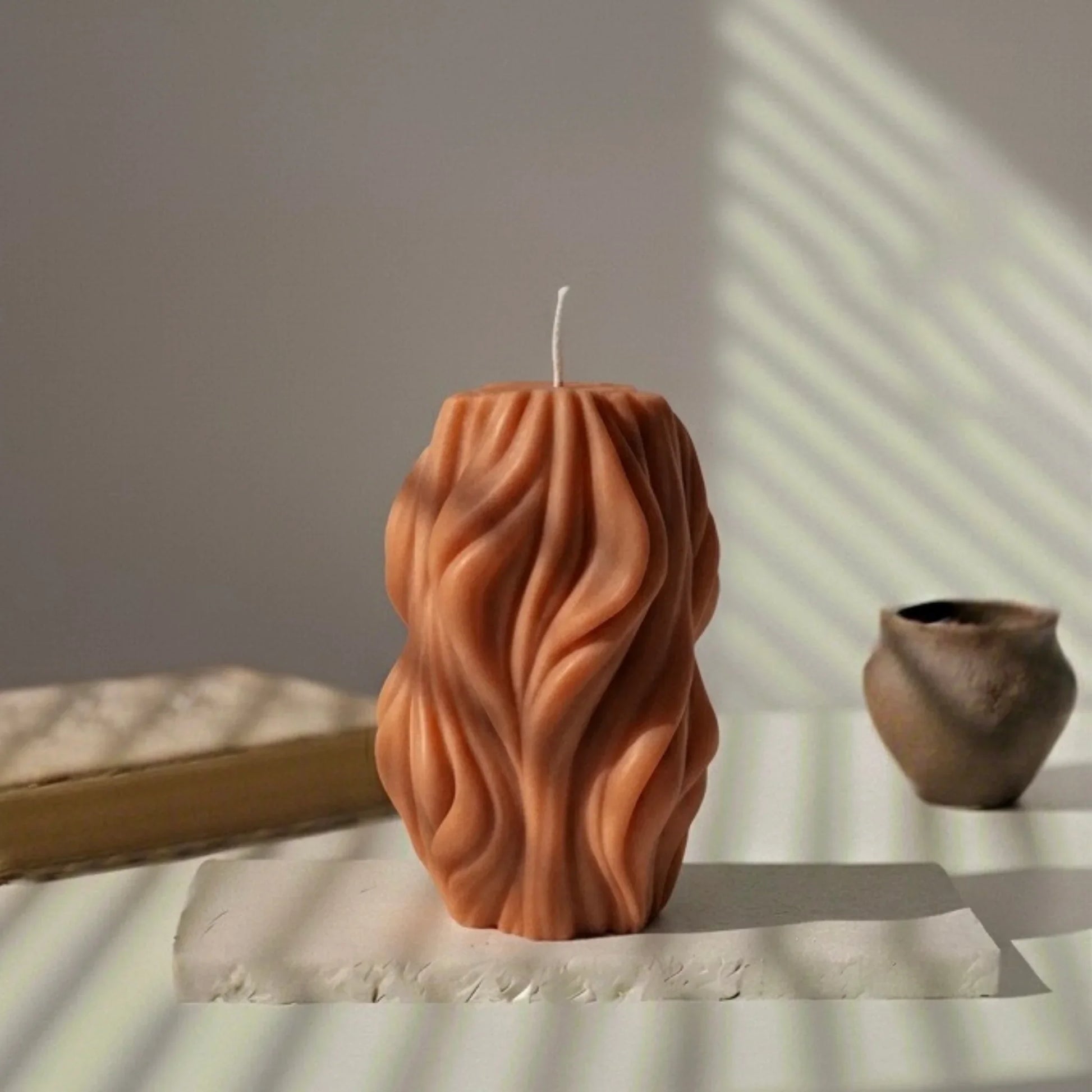 Bougie torsadée terracotta décorative sur table, lumière naturelle, style artisanal L'Atelier Rochelais