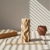 Bougie design vague beige sur socle en pierre, ambiance artisanale L’Atelier Rochelais