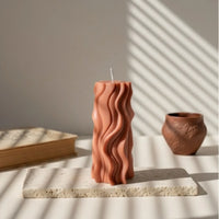 Bougie vague design terracotta sur pierre, ambiance artisanale L'Atelier Rochelais