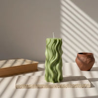 Bougie décorative vert kaki à motif vague sur socle, ambiance élégante Atelier Rochelais