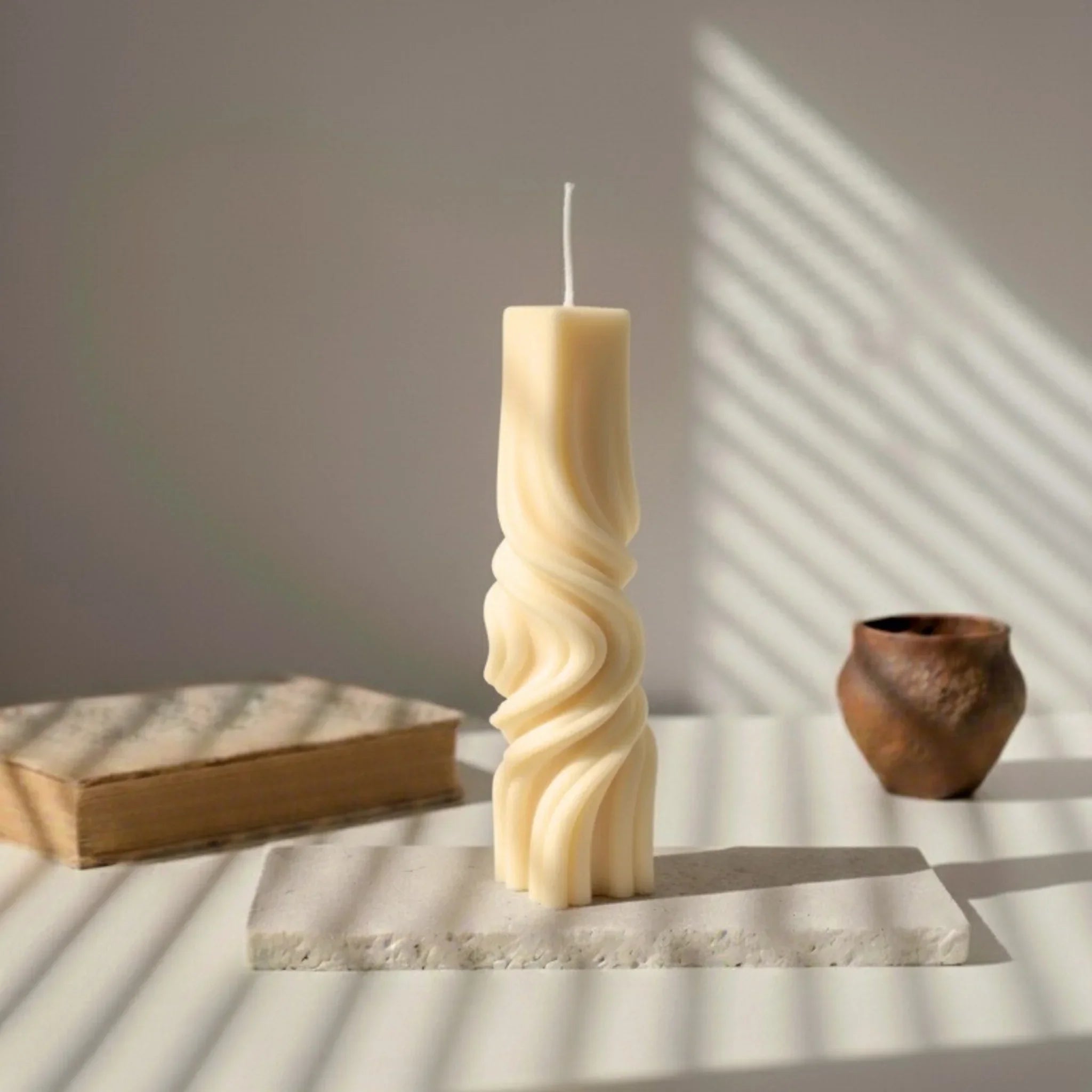 Bougie totem décorative blanche sur support, éclairage naturel, style artisanal et élégant