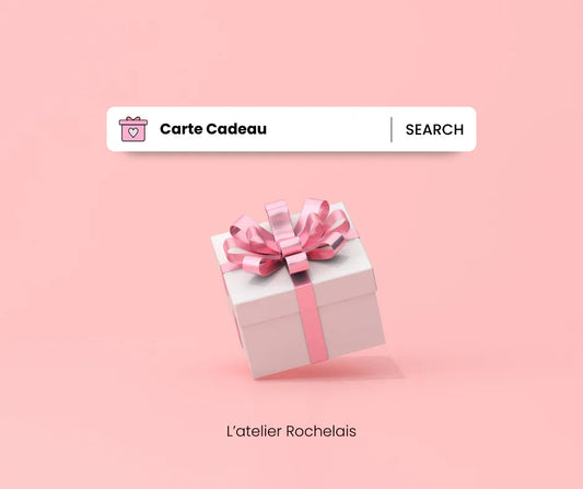 Carte cadeau L'Atelier Rochelais, boîte cadeau blanche avec ruban rose sur fond rose.
