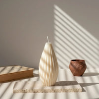 Bougie Montgolfière ivoire design posée sur une table éclairée, style artisanal L'Atelier Rochelais