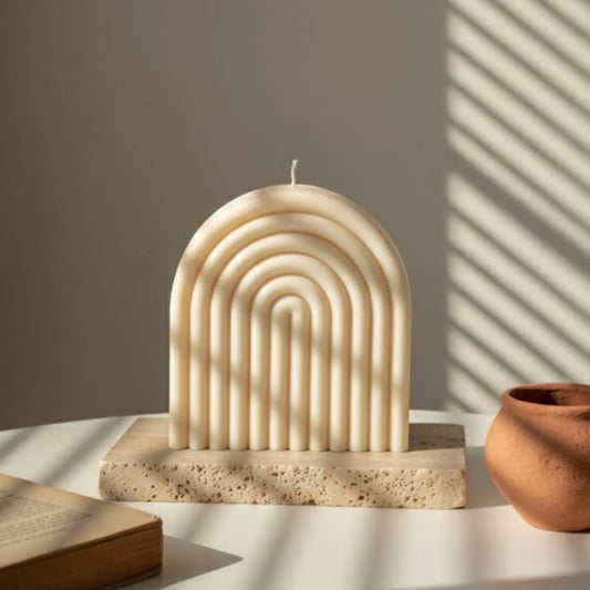 Bougie artisanale ivoire en forme d'arche sur table, lumière naturelle, L'Atelier Rochelais