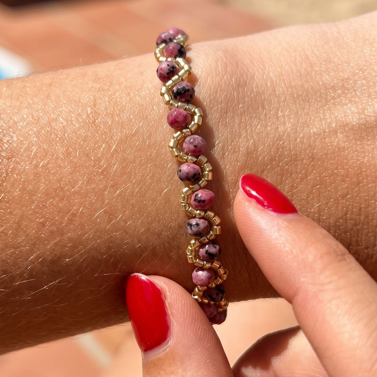 Bracelet Maya violet foncé porté au poignet bijou artisanal perles dorées La Rochelle